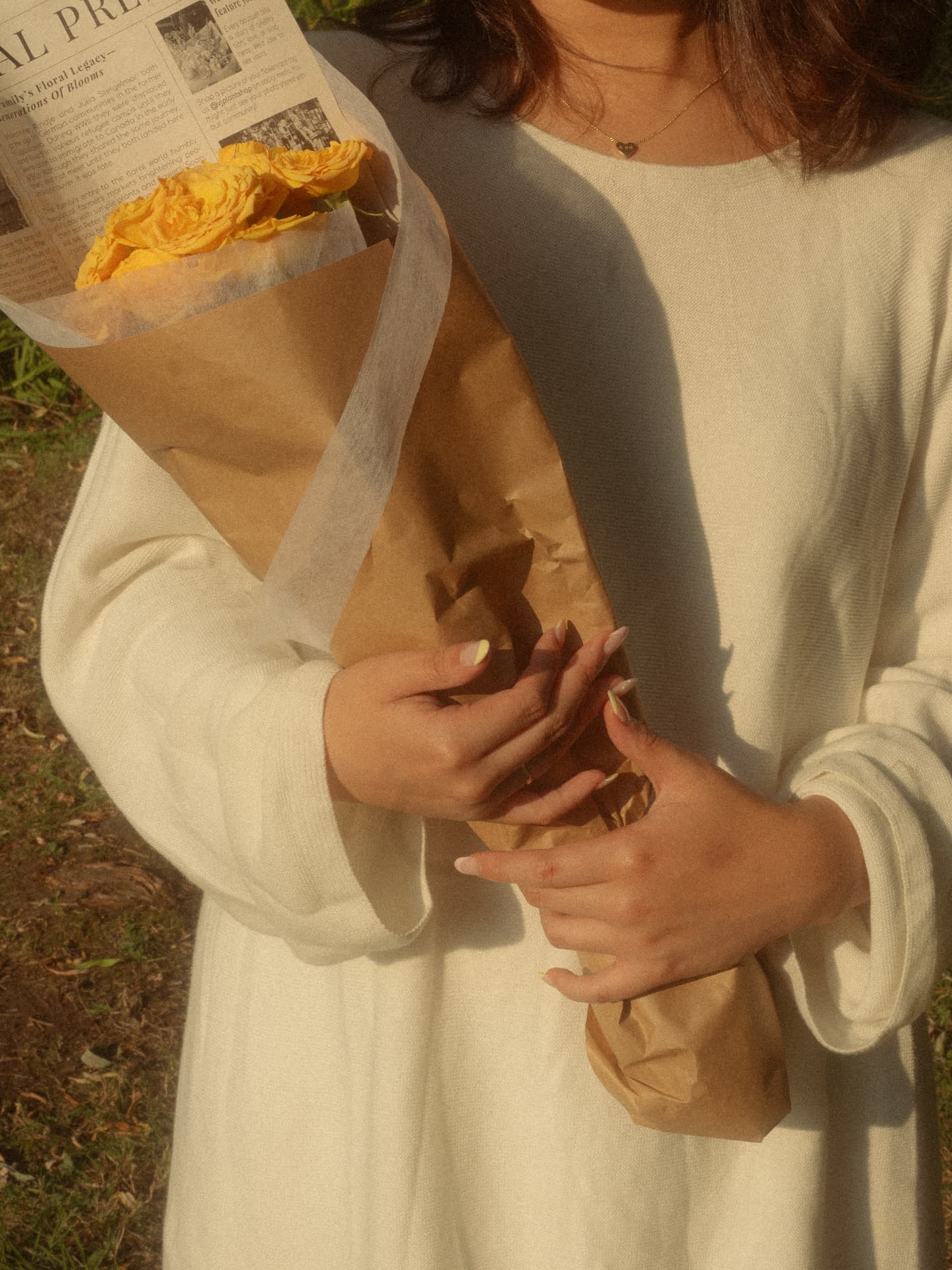 Close-up of hands holding a bouquet of yellow roses in a gentle Metro Vancouver setting