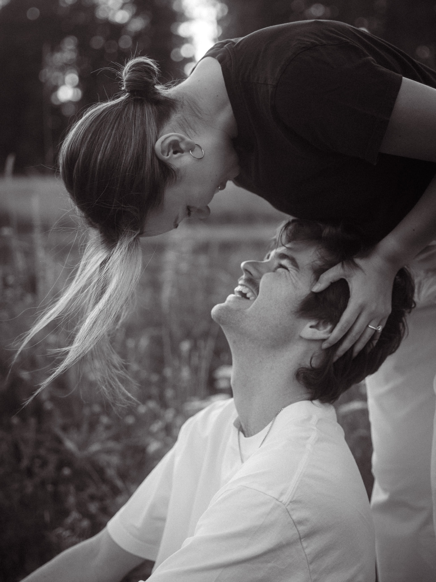 Black and white engagement photo of a couple laughing during a Metro Vancouver session